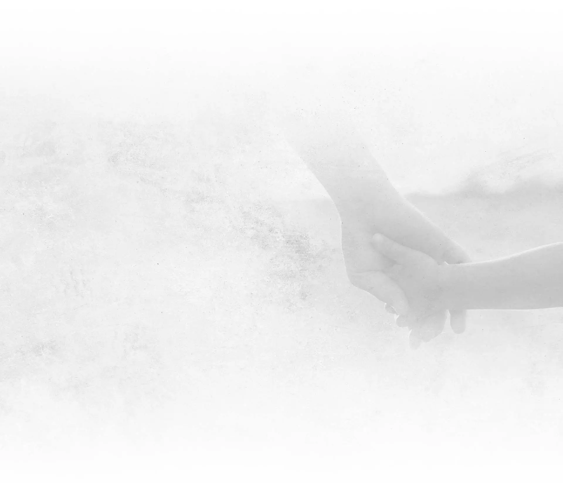 Two hands gently holding each other against a soft, white textured background symbolizing care and support.