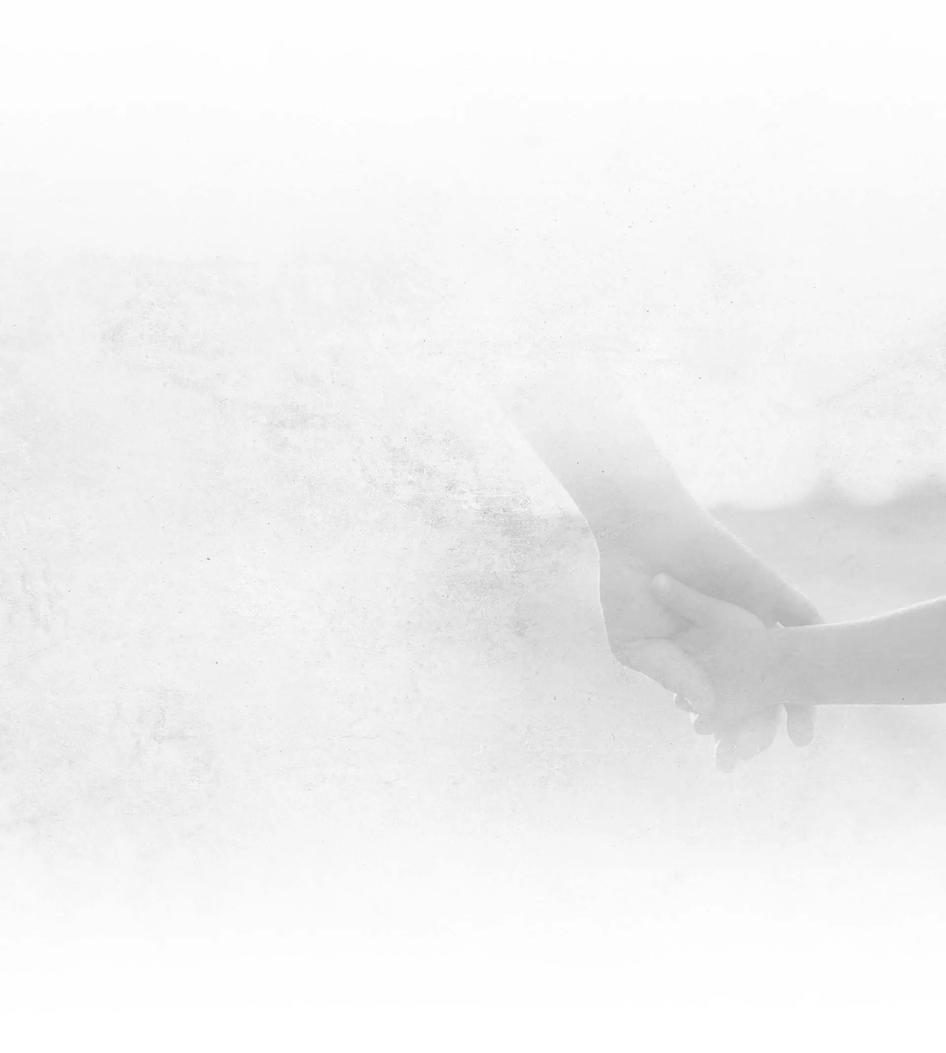 Two hands gently holding each other against a soft, white textured background symbolizing care and support.