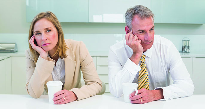 Bored business couple having coffee before work in morning.