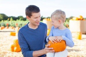 Little Boy Sitting Holding His Pumpkin