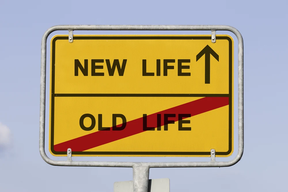 A yellow German-style road sign showing 'OLD LIFE' crossed out in red at the bottom and 'NEW LIFE' with an upward arrow at the top.