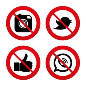 Four red 'prohibited' signs: no photography, no Twitter/X, no 'likes' (thumbs up), and no WhatsApp. A digital detox or privacy concept.